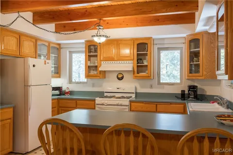a kitchen with stainless steel appliances granite countertop a sink a stove and a refrigerator