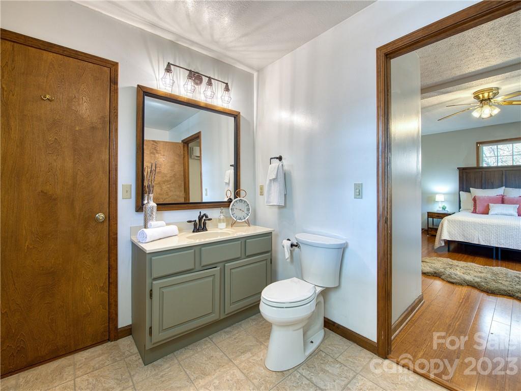 353 Rustic Heights Road Waynesville, NC 28785 - Photo 24 of 46 a bathroom with a toilet sink and mirror