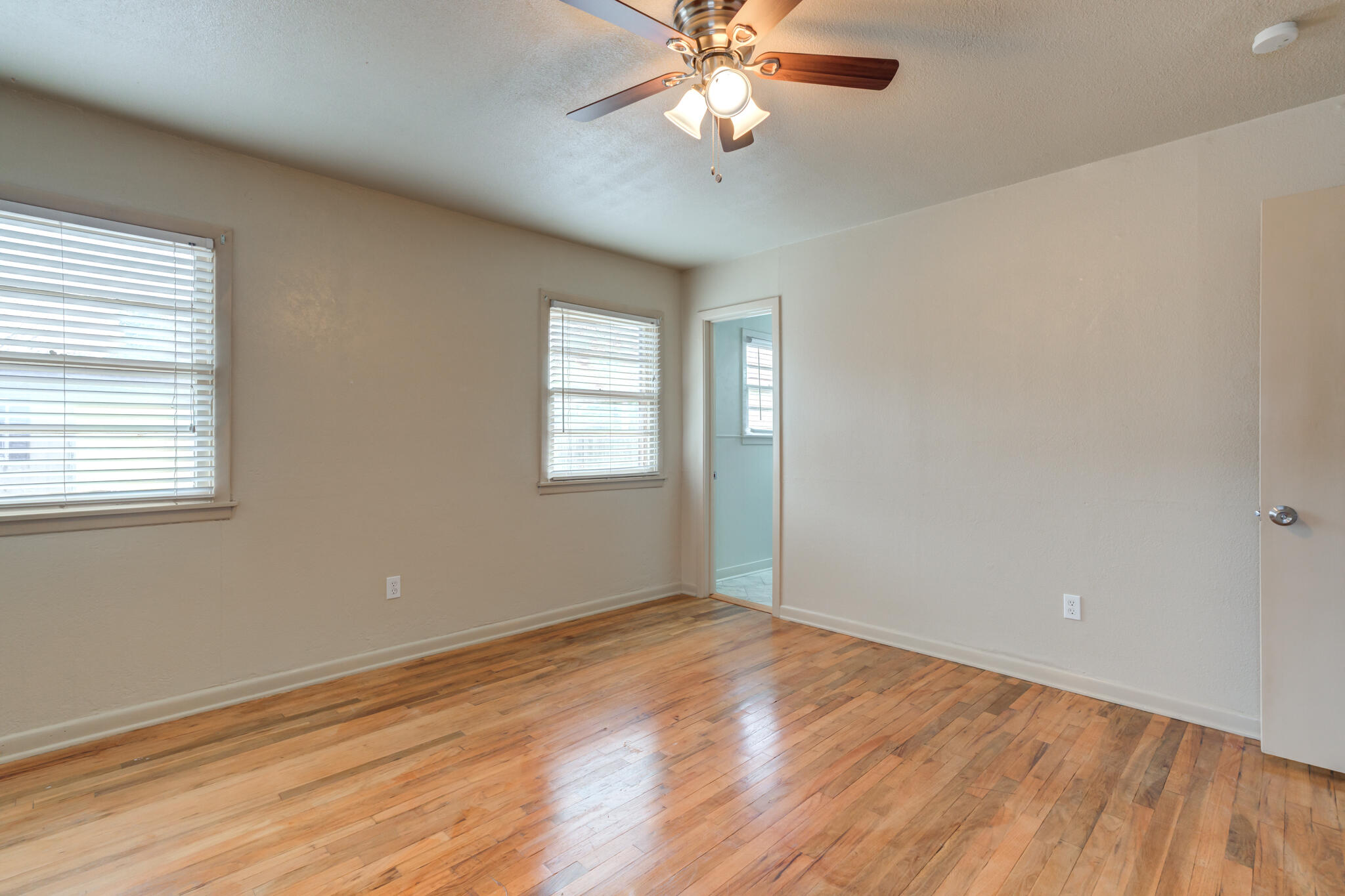 3517 47th Street Lubbock, TX 79413 - Photo 21 of 36 a view of an empty room with wooden floor and a window