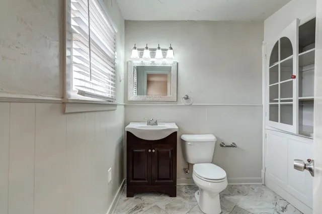 a bathroom with a toilet a sink and mirror
