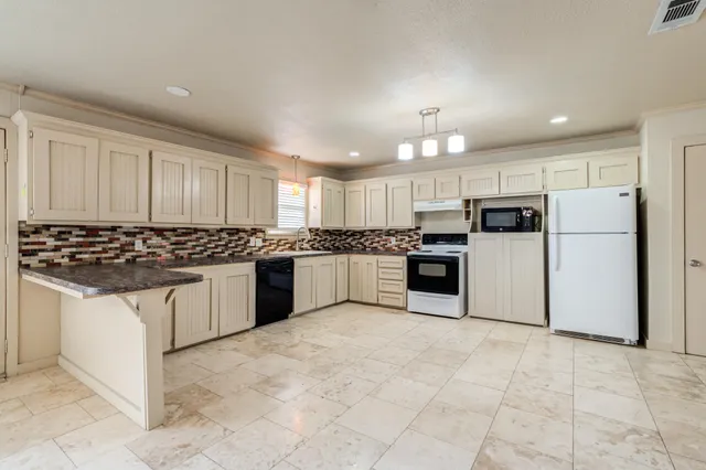 a large kitchen with cabinets and stainless steel appliances