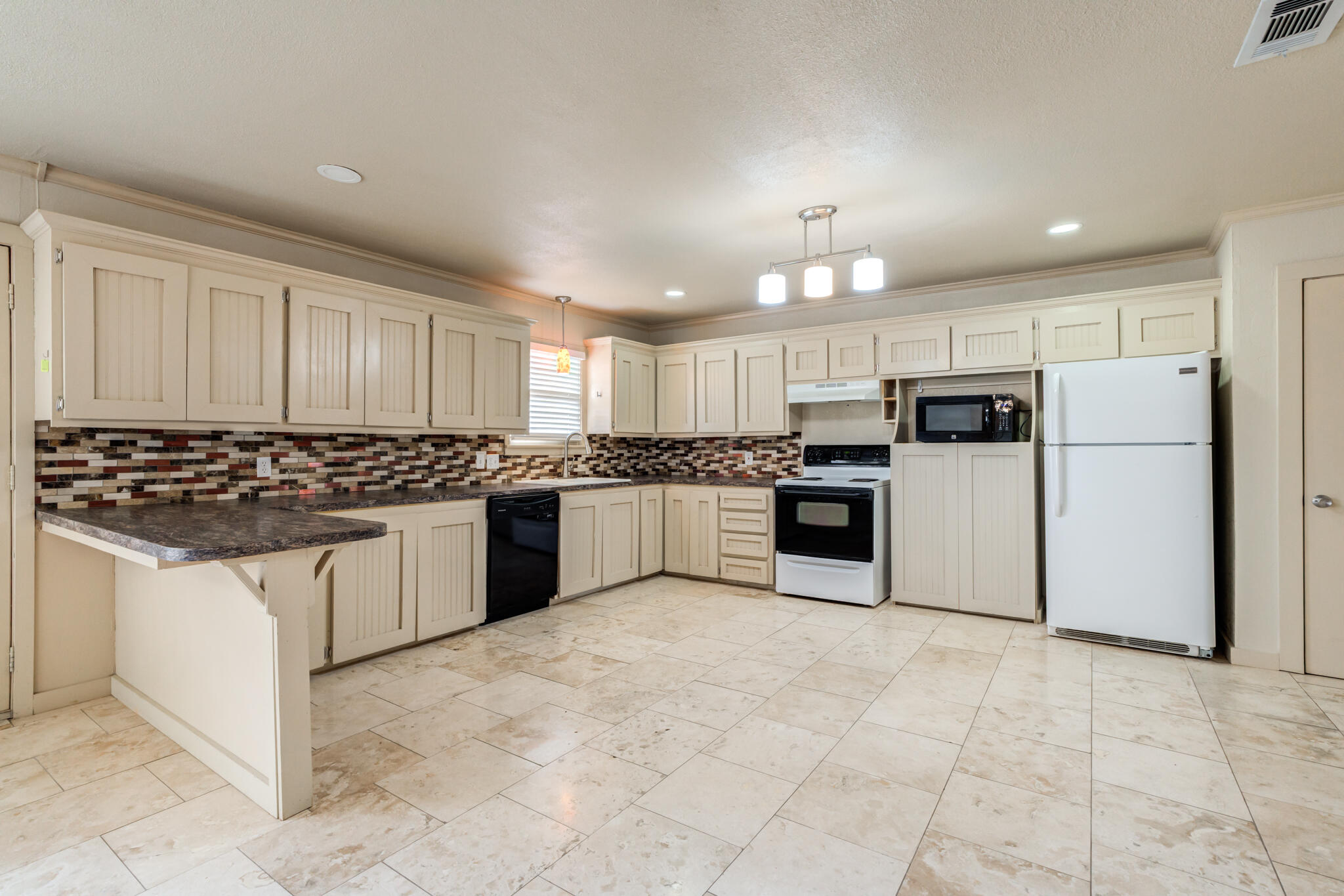 3517 47th Street Lubbock, TX 79413 - Photo 6 of 36 a large kitchen with cabinets and stainless steel appliances