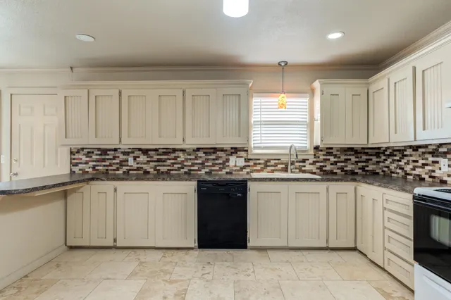 a kitchen with granite countertop white cabinets and stainless steel appliances