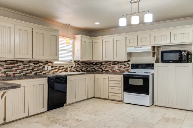 a kitchen with stainless steel appliances granite countertop a stove a sink and a microwave