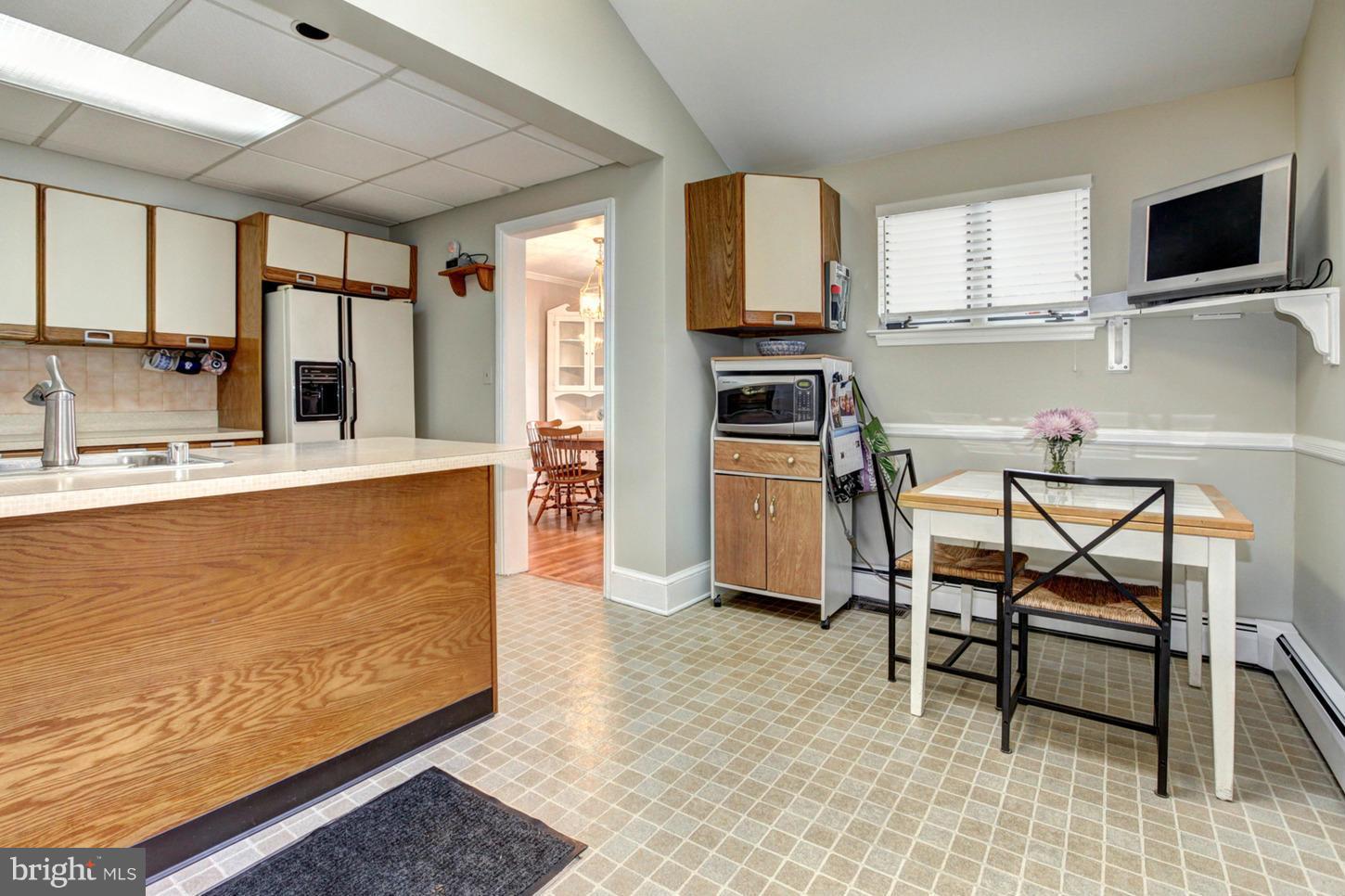 10009 Sutherland Road Silver Spring, MD 20901 - Photo 9 of 27 a living room with stainless steel appliances kitchen island granite countertop furniture and a flat screen tv