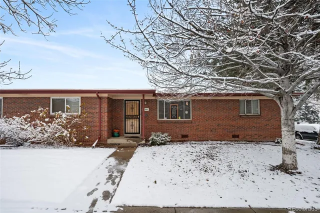 a front view of a house with a yard covered in snow