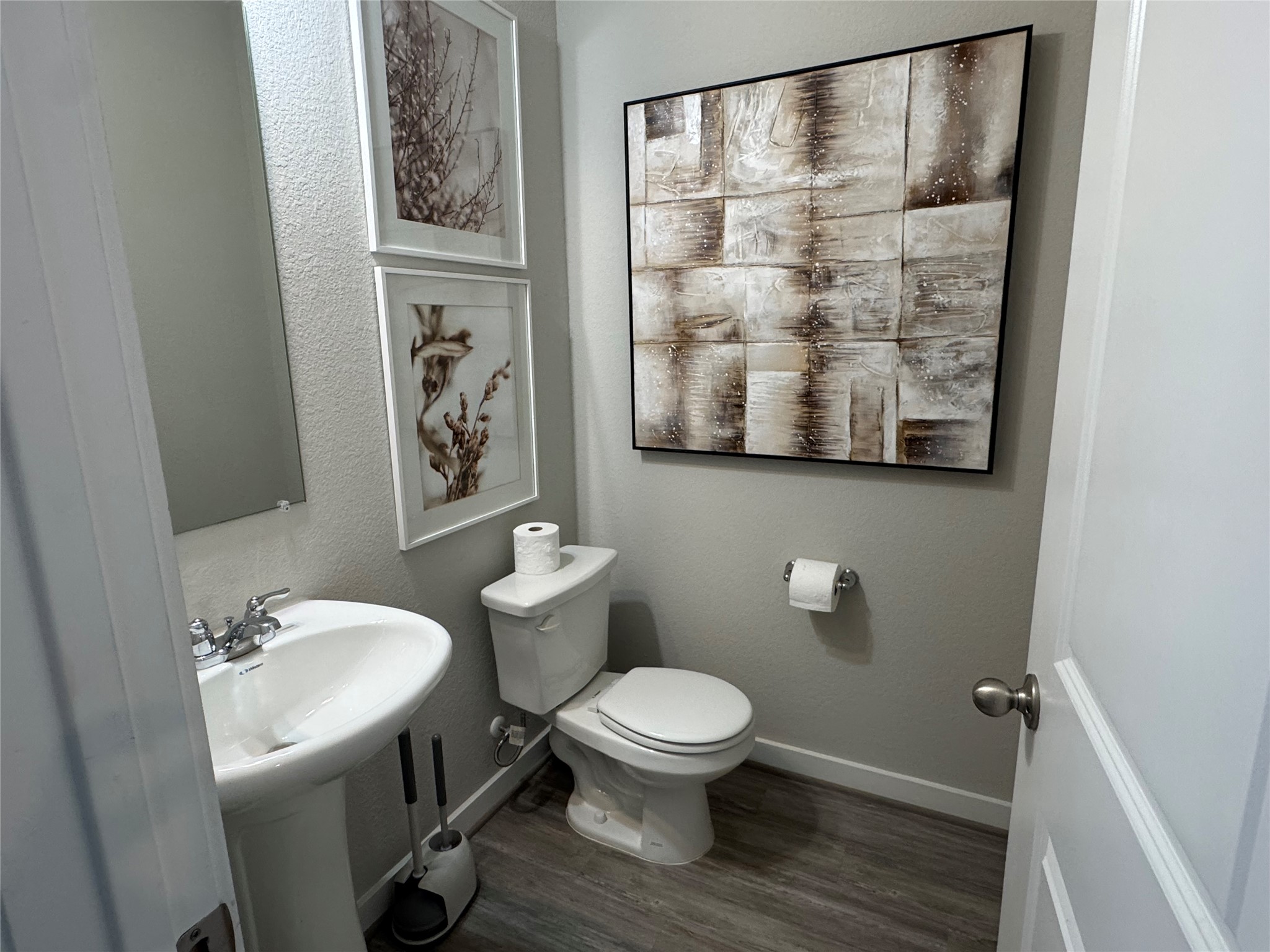 2328 Calvert Drive Leander, TX 78641 - Photo 28 of 35 Powder room featuring a pedestal sink with chrome faucet, a white toilet, and wood-finish flooring
