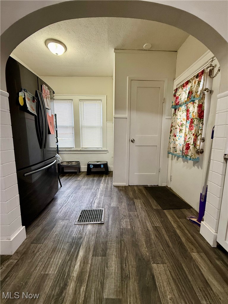 935 Ridge Road Northwest Canton, OH 44703 - Photo 11 of 32 Mudroom with arched walkways, a textured ceiling, and dark wood finished floors