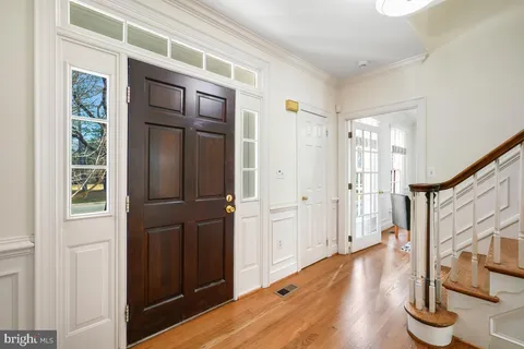 a view of front door with wooden floor and stairs