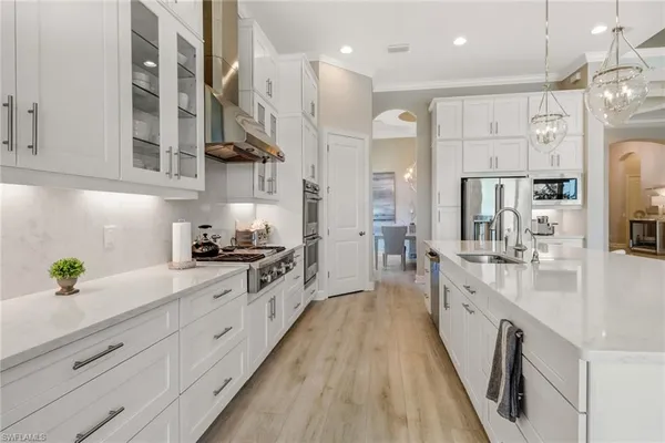 a large kitchen with stainless steel appliances lots of counter space and wooden floor