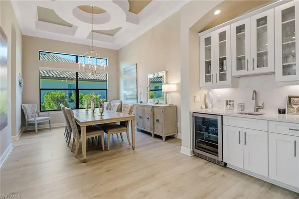 a dining room with furniture a rug and a floor to ceiling window