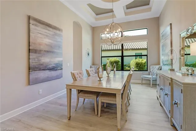 a dining room with furniture a chandelier and wooden floor