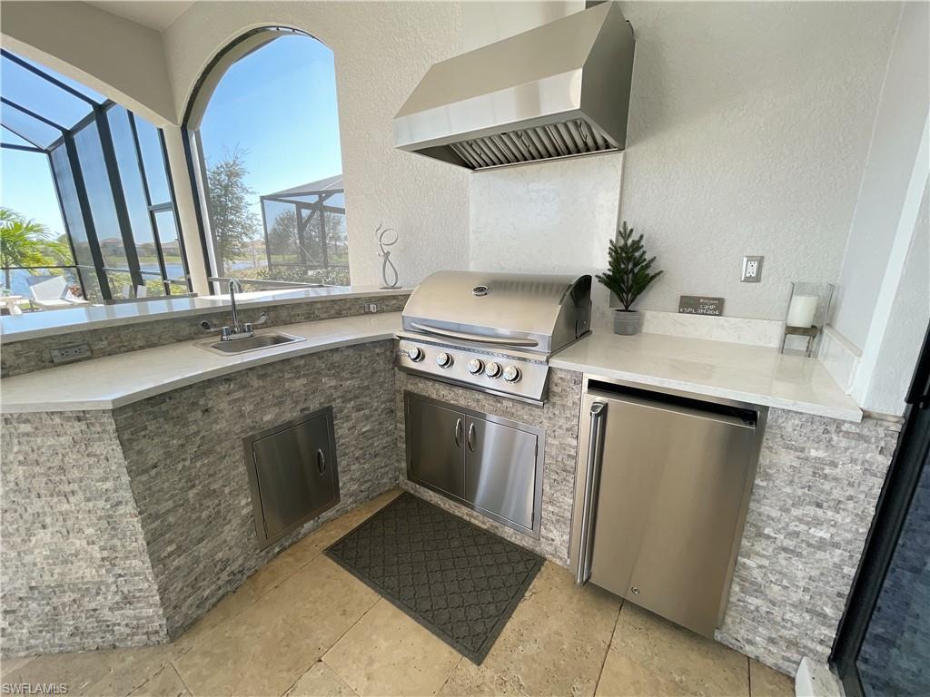 9412 Rapallo Street Naples, FL 34119 - Photo 18 of 34 a kitchen with a stove and a sink