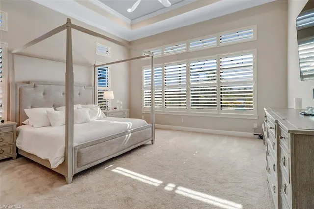 a bedroom with a bed lamp and a large window