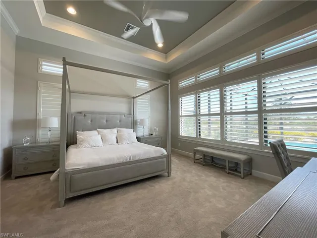 a bedroom with a bed couch and a large window