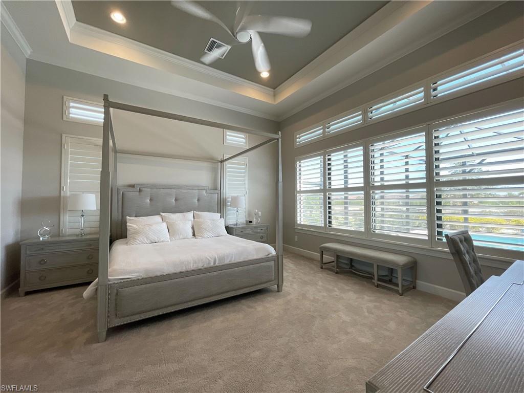 9412 Rapallo Street Naples, FL 34119 - Photo 21 of 34 a bedroom with a bed couch and a large window