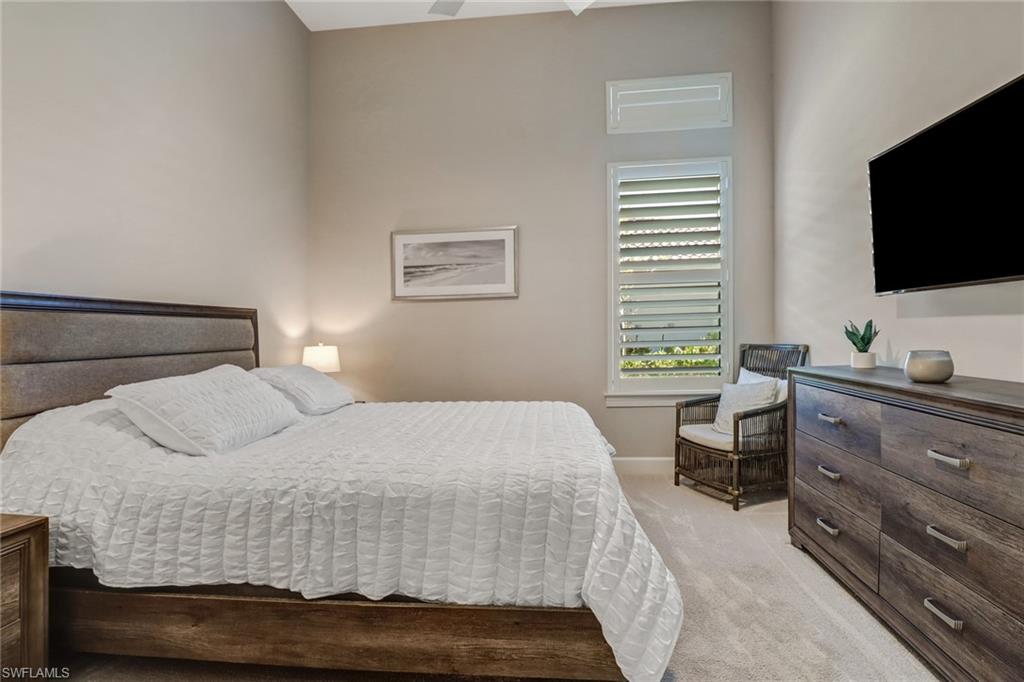 9412 Rapallo Street Naples, FL 34119 - Photo 22 of 34 a bedroom with a bed and a flat screen tv