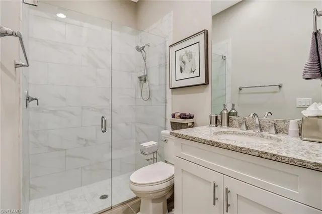a bathroom with a granite countertop sink toilet and shower