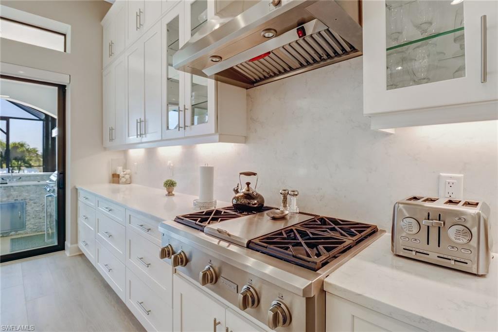 9412 Rapallo Street Naples, FL 34119 - Photo 10 of 34 a kitchen with granite countertop a stove and a sink