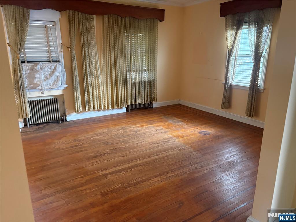 429 MacArthur Avenue Garfield, NJ 07026 - Photo 19 of 38 an empty room with wooden floor and windows