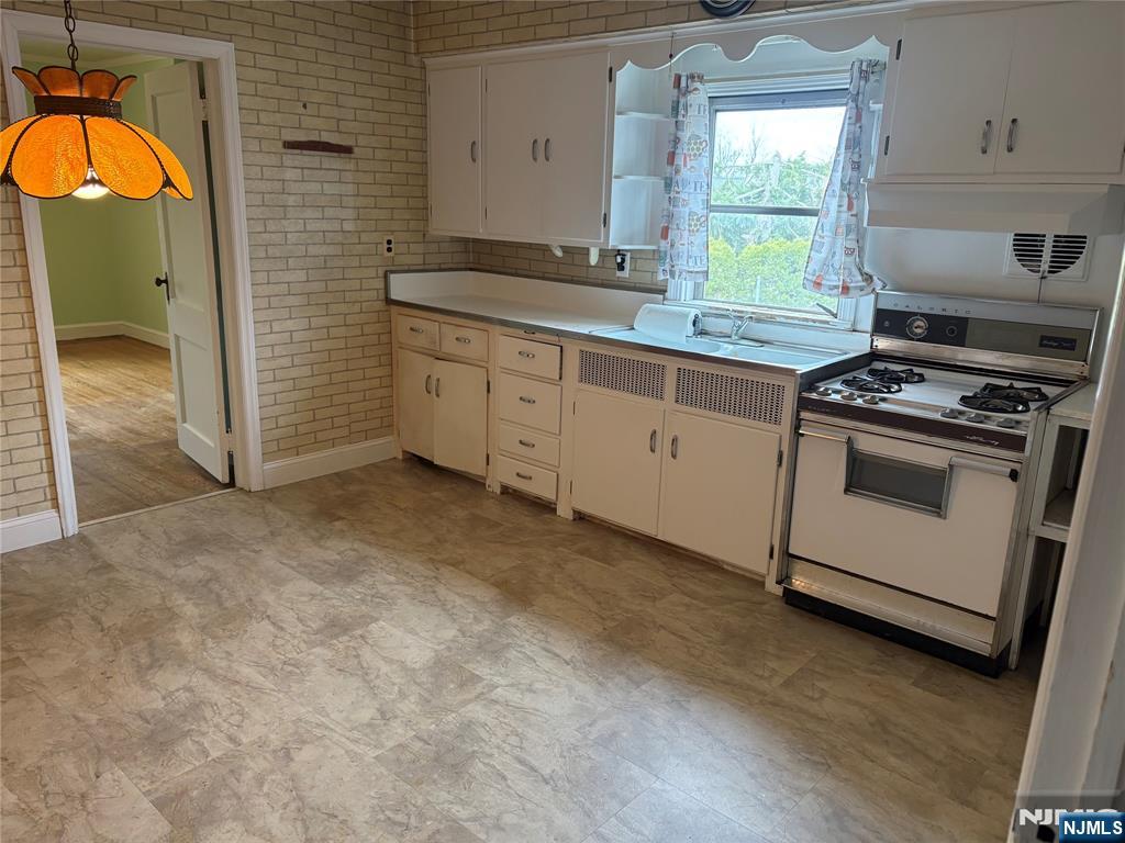 429 MacArthur Avenue Garfield, NJ 07026 - Photo 24 of 38 a kitchen with granite countertop a stove a sink and a dishwasher