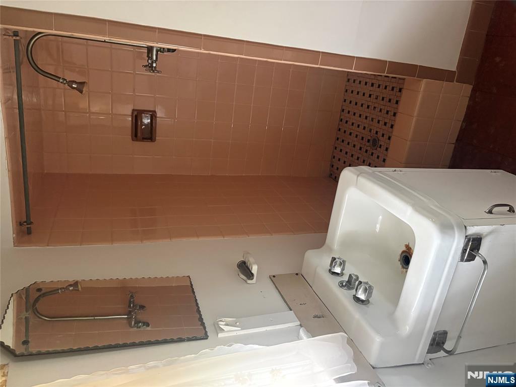 429 MacArthur Avenue Garfield, NJ 07026 - Photo 27 of 38 a bathroom with a sink and mirror