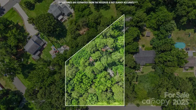 an aerial view of residential house with outdoor space and trees all around