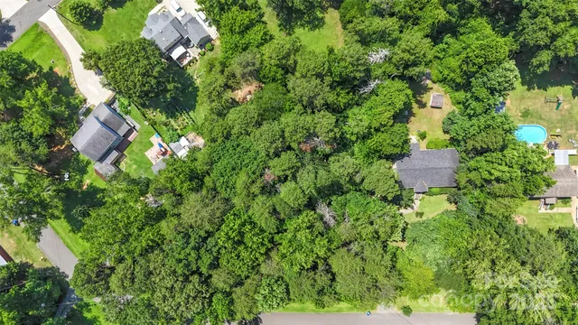 an aerial view of residential house with outdoor space and trees all around
