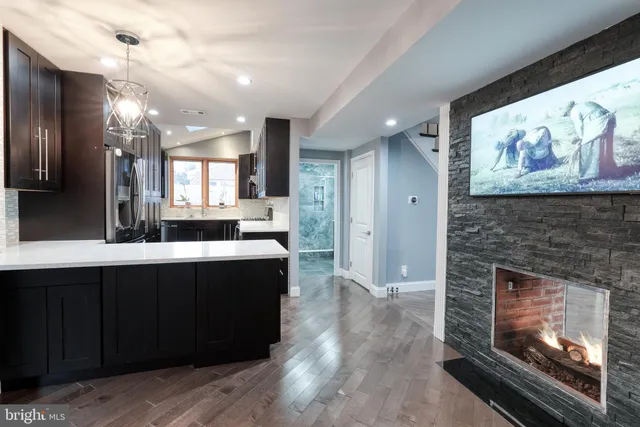 a large kitchen with a stove a refrigerator and a fireplace