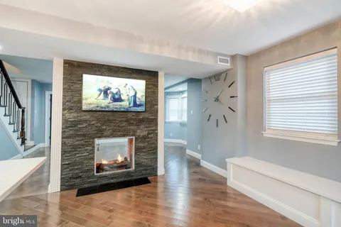 a living room with furniture a fireplace and a large window