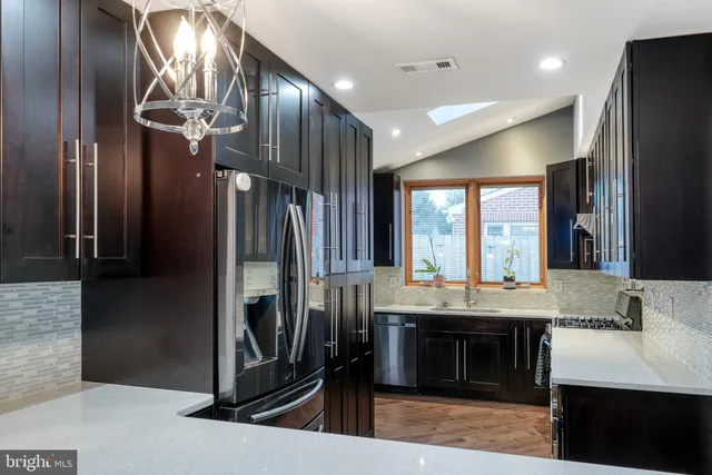 a kitchen with stainless steel appliances granite countertop a refrigerator and a sink