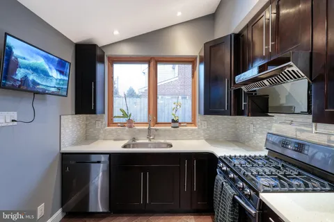 a kitchen with stainless steel appliances a sink stove and cabinets