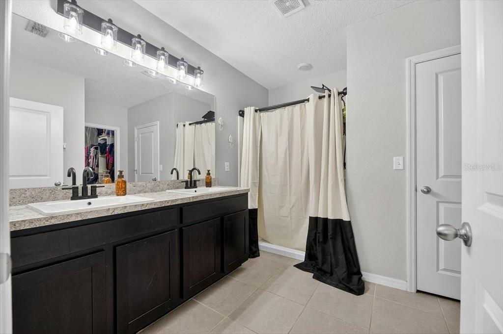 3246 South Northview Road Plant City, FL 33566 - Photo 23 of 57 a bathroom with a double vanity sink and a mirror