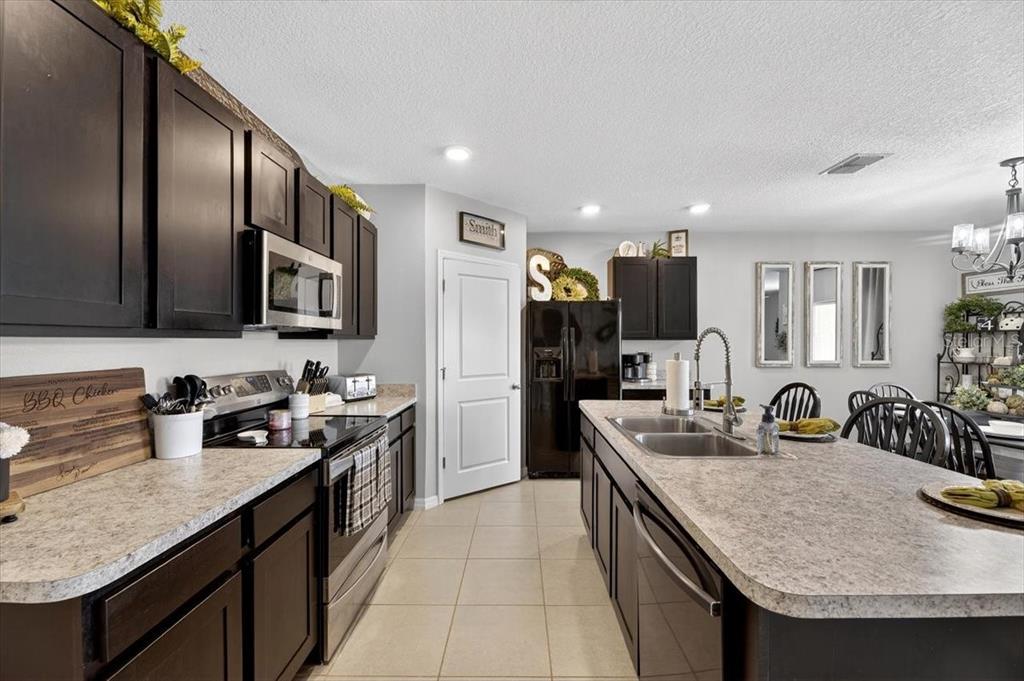 3246 South Northview Road Plant City, FL 33566 - Photo 3 of 57 a kitchen with granite countertop kitchen island stainless steel appliances a sink stove top oven and refrigerator