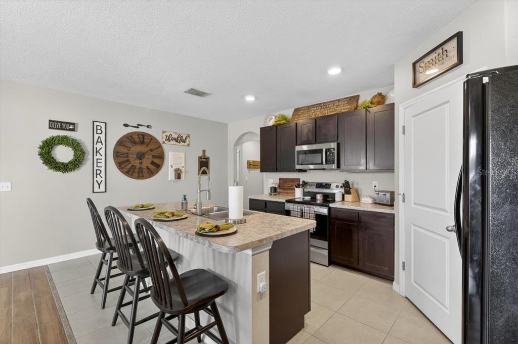 3246 South Northview Road Plant City, FL 33566 - Photo 8 of 57 a kitchen with stainless steel appliances granite countertop a refrigerator a stove a sink a dining table and chairs