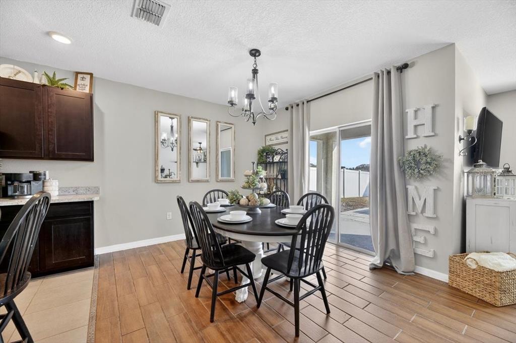3246 South Northview Road Plant City, FL 33566 - Photo 10 of 57 a dining room with furniture wooden floor a chandelier and a rug