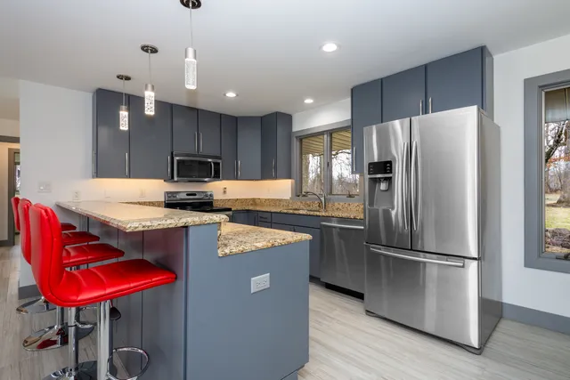 a kitchen with granite countertop stainless steel appliances and wooden cabinets
