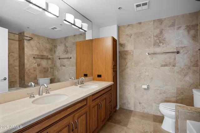 a bathroom with a double vanity sink toilet and a mirror