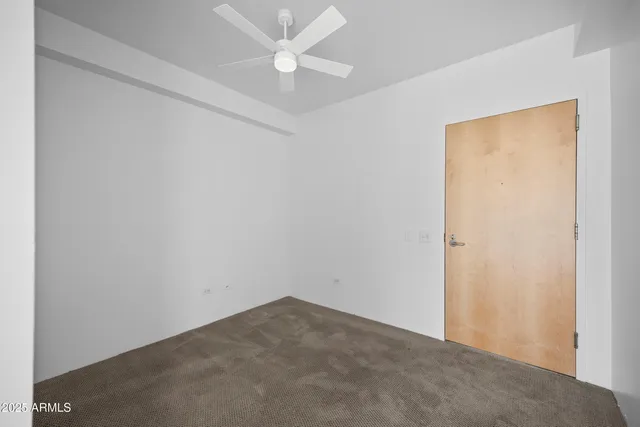 an empty room with a ceiling fan and a window