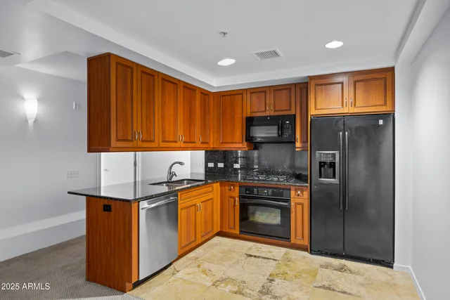a kitchen with stainless steel appliances granite countertop a stove a sink dishwasher a refrigerator and a microwave oven