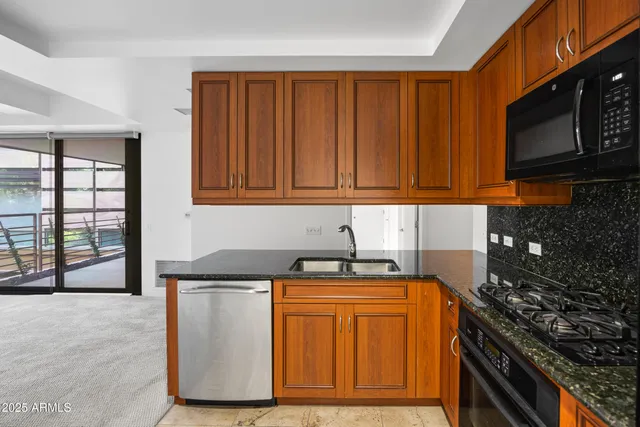 a kitchen with stainless steel appliances granite countertop a stove a sink and a microwave