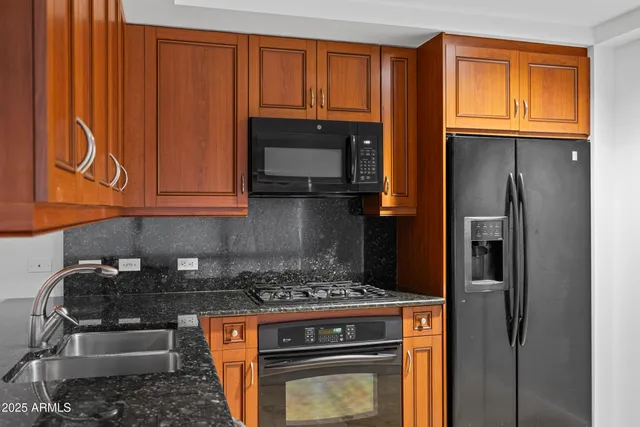 a kitchen with stainless steel appliances granite countertop a refrigerator stove and microwave