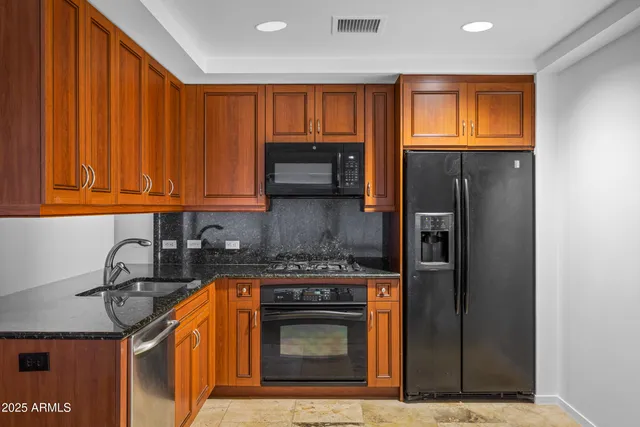 a kitchen with stainless steel appliances granite countertop a stove top oven microwave and refrigerator