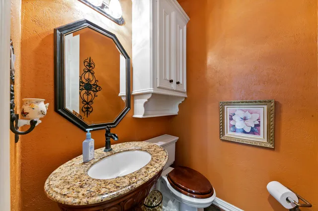 a bathroom with a sink a toilet and mirror