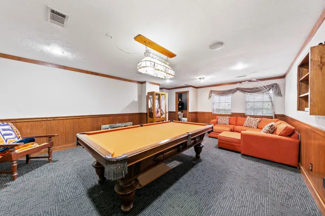 a view of a house with a big yard and large trees