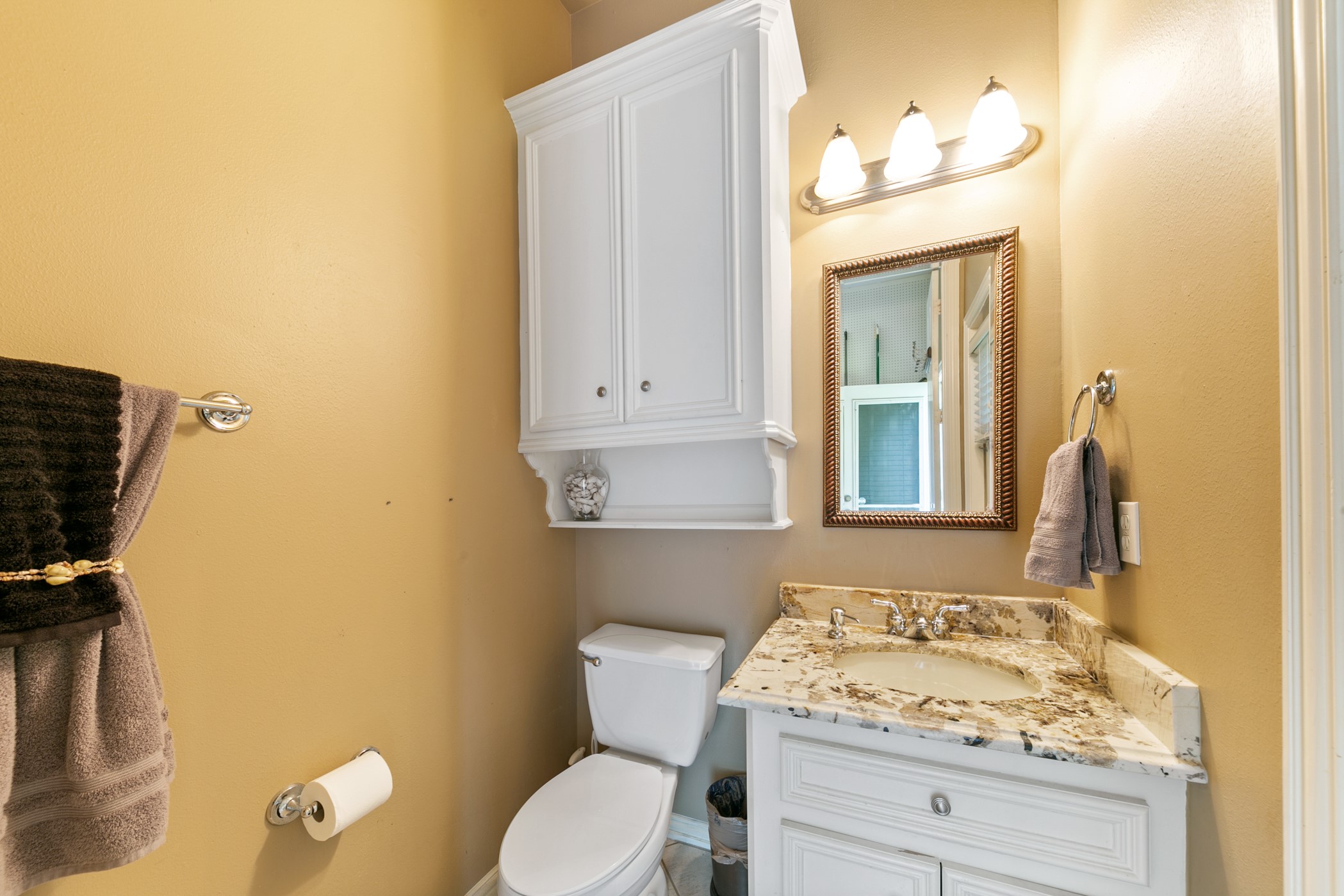 13915 Springmint Drive Cypress, TX 77429 - Photo 41 of 43 a bathroom with a granite countertop toilet sink and mirror
