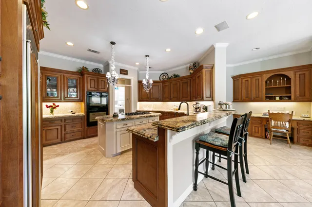 a kitchen with stainless steel appliances granite countertop a stove top oven a sink a dining table and chairs