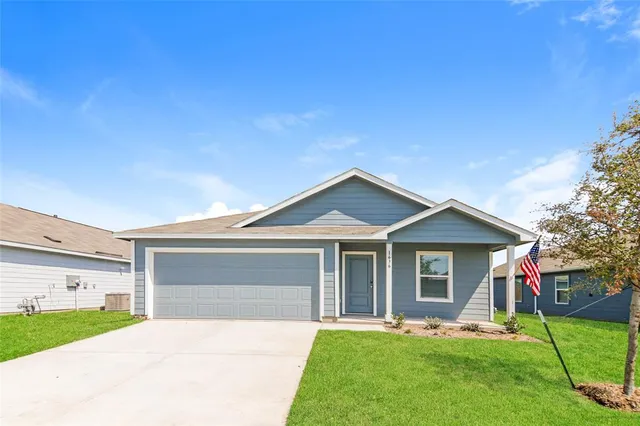 a front view of a house with a garden and yard