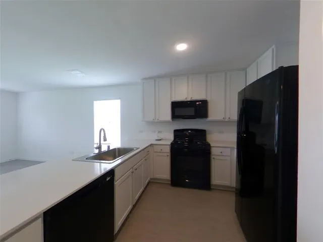 a kitchen with stainless steel appliances granite countertop a refrigerator a stove a sink and a microwave