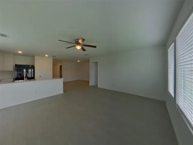 a view of a livingroom with a ceiling fan and window